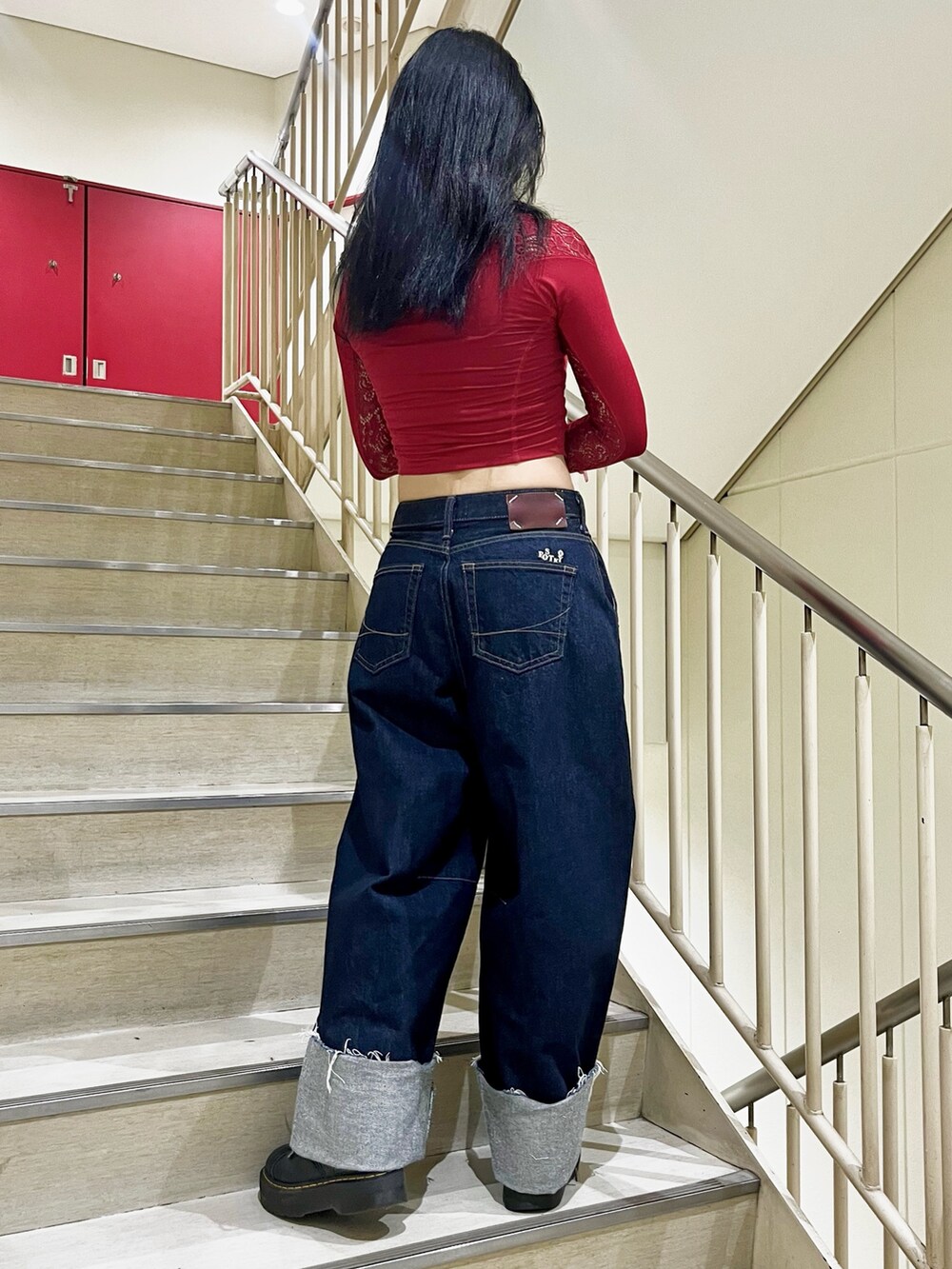 ブルー系のデニムパンツ、レッド系のTシャツ/カットソー、ブラック系のサングラスを着用したレディースの夏コーディネートの3枚目の写真