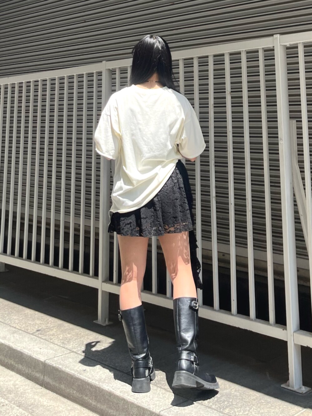 ブラック系のスカート、ホワイト系のTシャツ/カットソー、シルバー系のチョーカーを着用したレディースの夏コーディネートの3枚目の写真