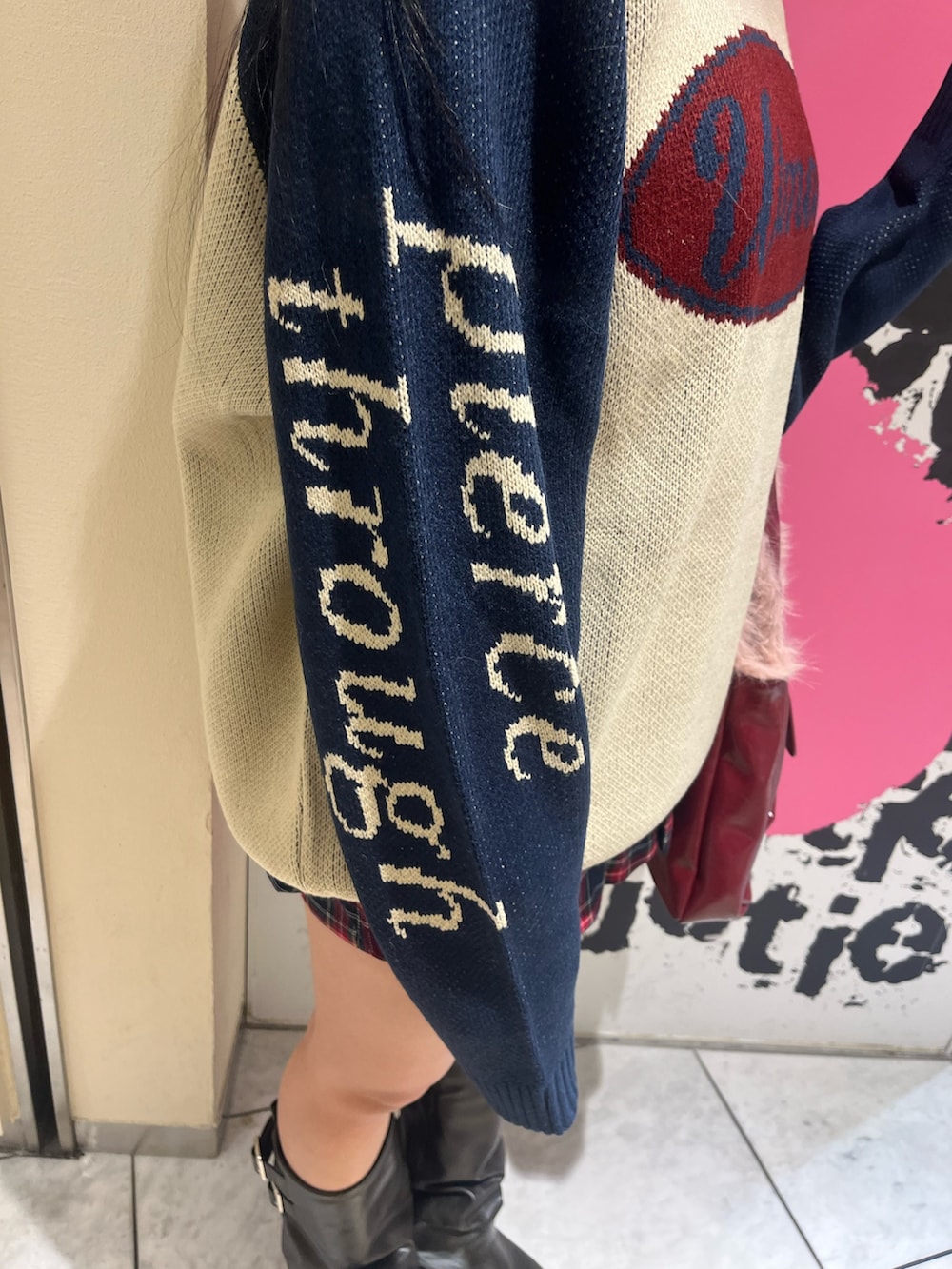 ホワイト系のニット/セーター、ブルー系のスカート、レッド系のハンドバッグを着用したレディースの冬コーディネートの6枚目の写真