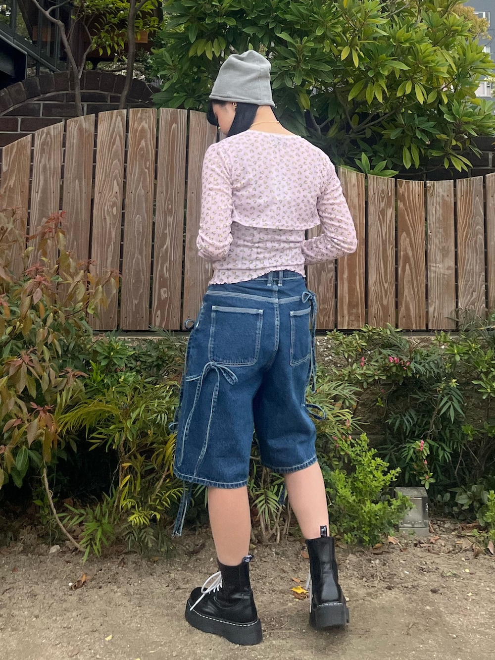 ブルー系のデニムパンツ、ピンク系のアンサンブル、ゴールド系のチョーカーを着用したレディースの春コーディネートの3枚目の写真