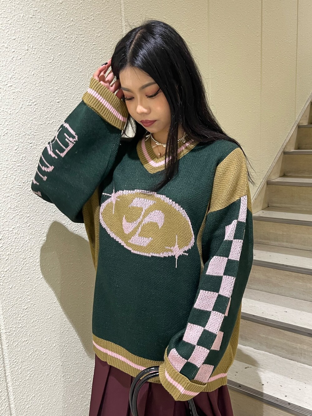 ブラック系のニット/セーター、レッド系のスカート、ブラック系のハンドバッグを着用したレディースの秋コーディネートの5枚目の写真