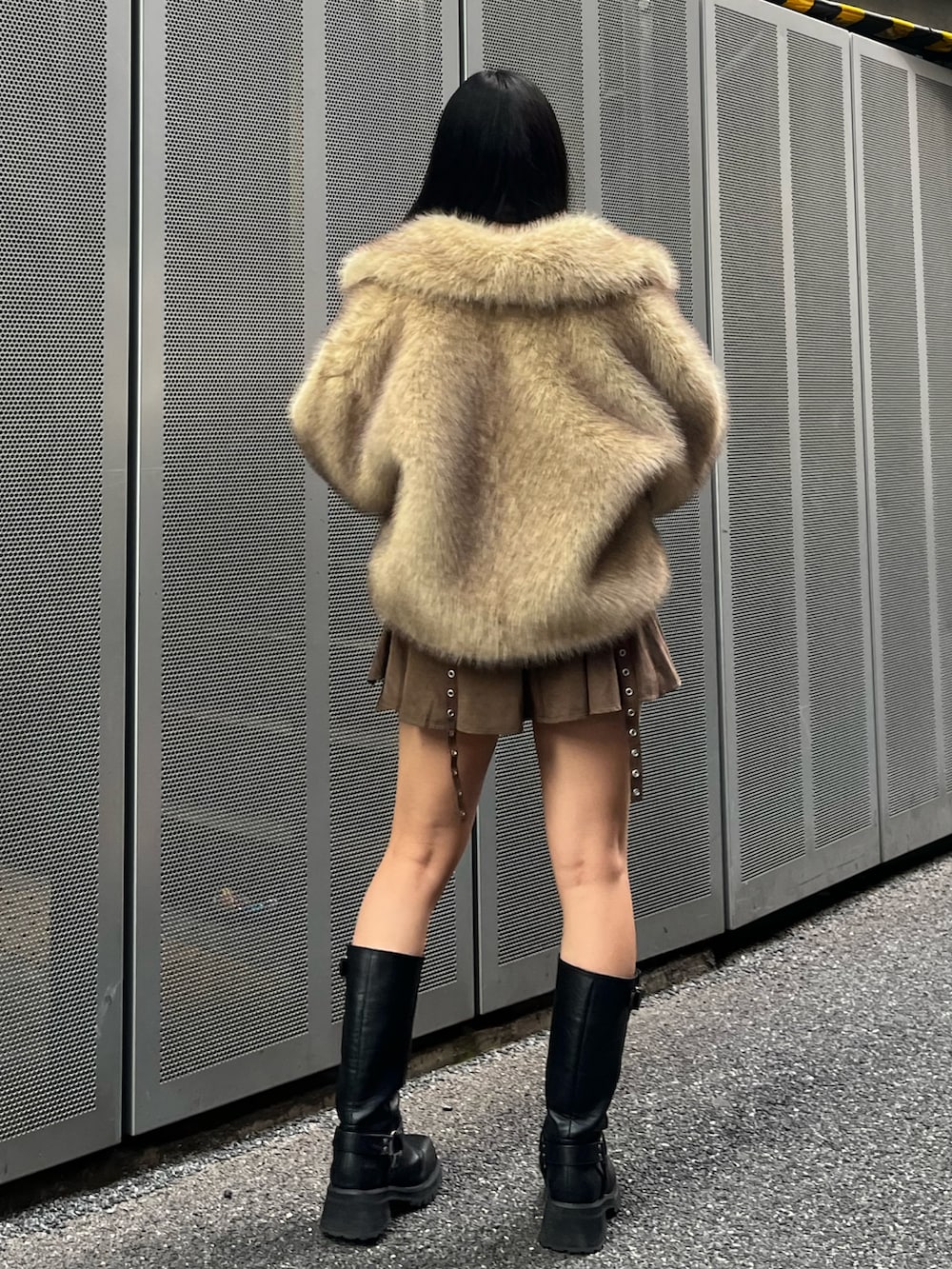 ブラウン系のスカート、ブラック系のブーツ、ベージュ系のその他アウターを着用したレディースの冬コーディネートの4枚目の写真