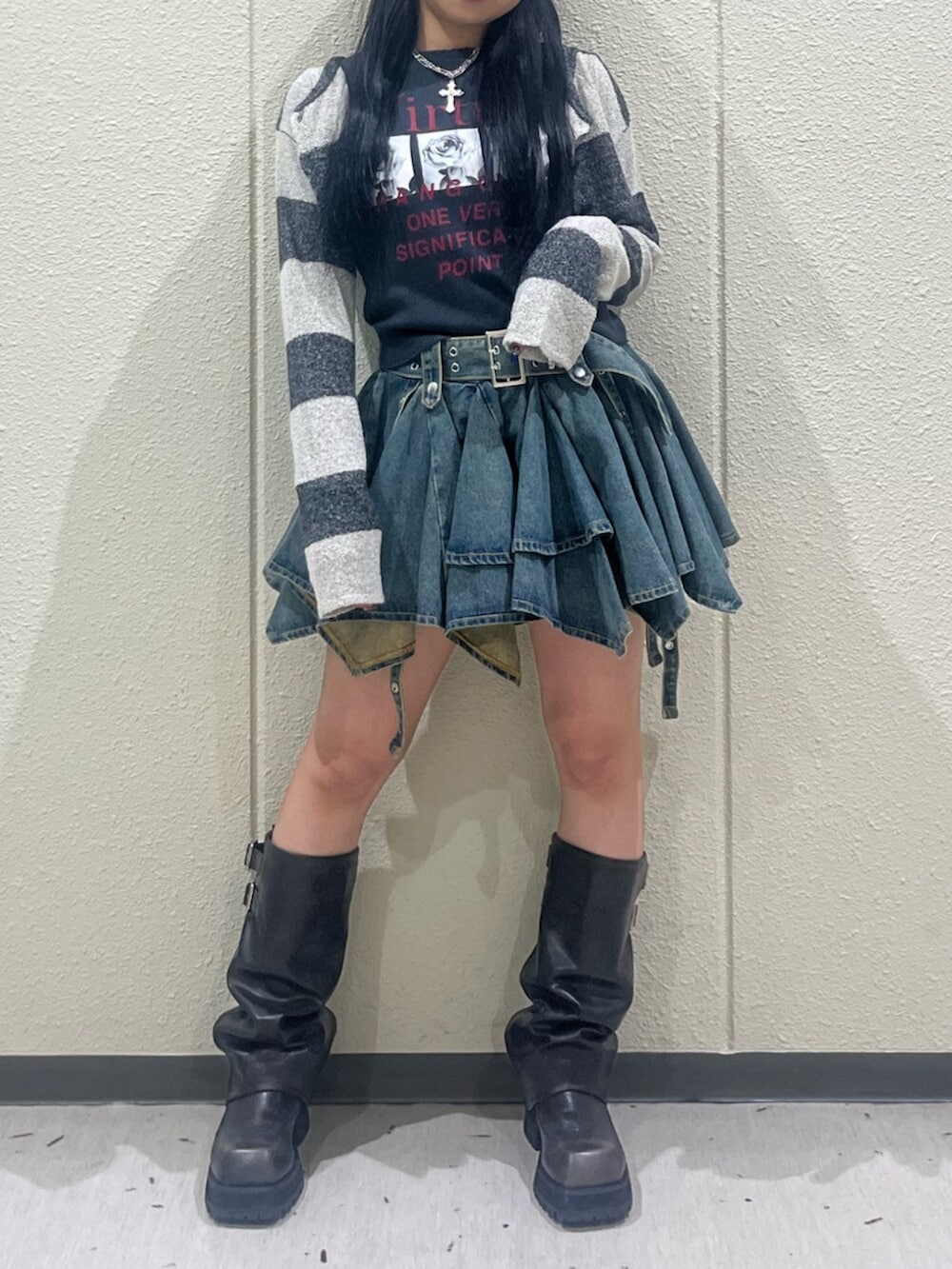 ブラック系のブーツ、ブルー系のデニムスカート、ブラック系のTシャツ/カットソーを着用したレディースの秋コーディネートの5枚目の写真