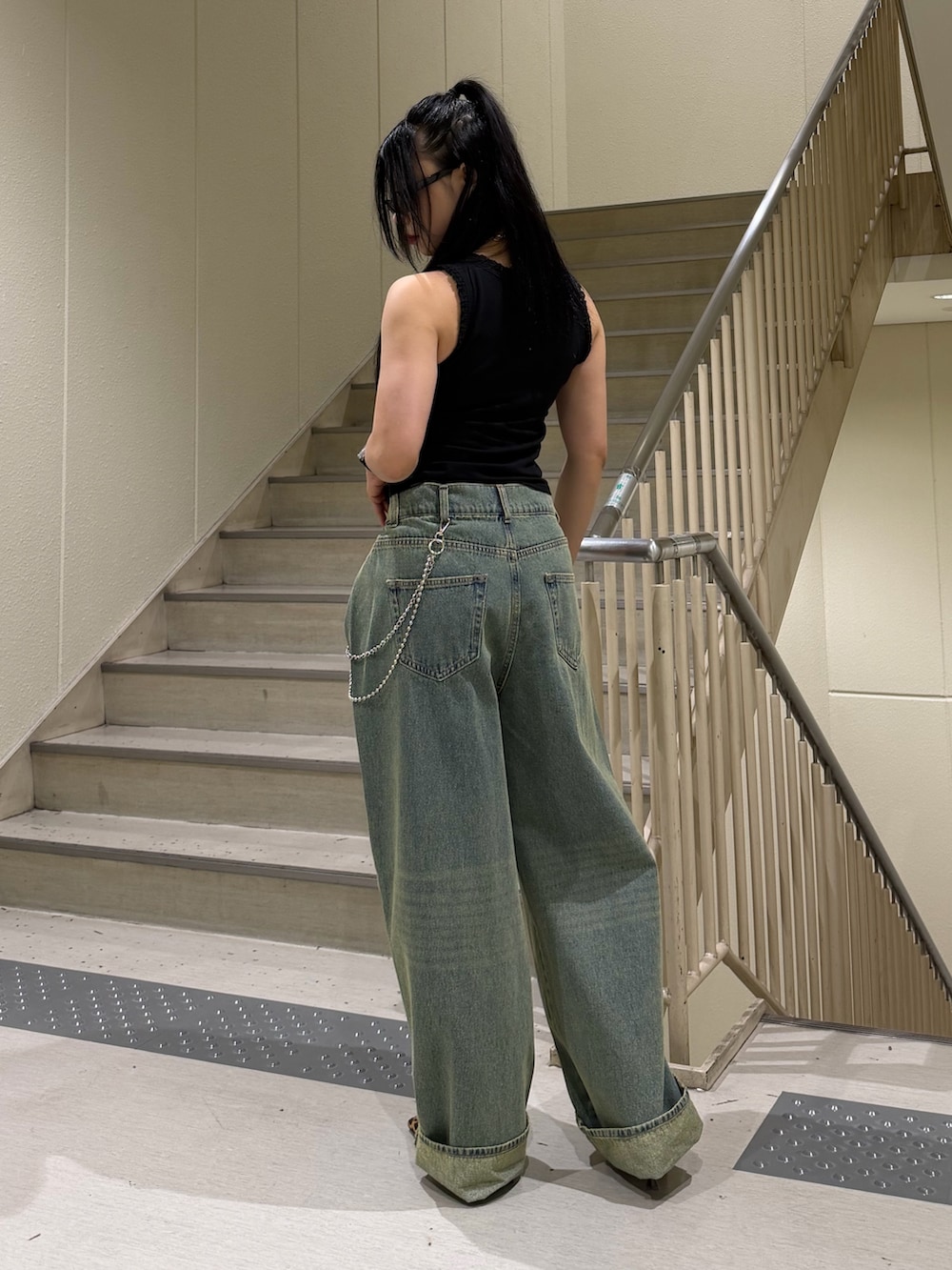 ブルー系のデニムパンツ、ブラック系のタンクトップ、ブラウン系のパンプスを着用したレディースの春コーディネートの3枚目の写真