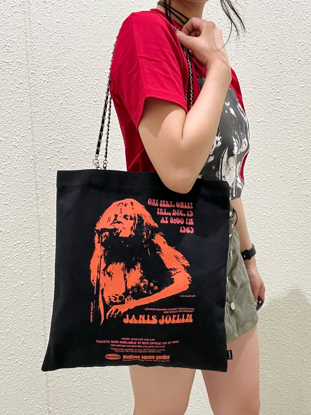 レッド系のTシャツ/カットソー、グリーン系のスカート、ブラック系のトートバッグを着用したレディースの夏コーディネートの7枚目の写真