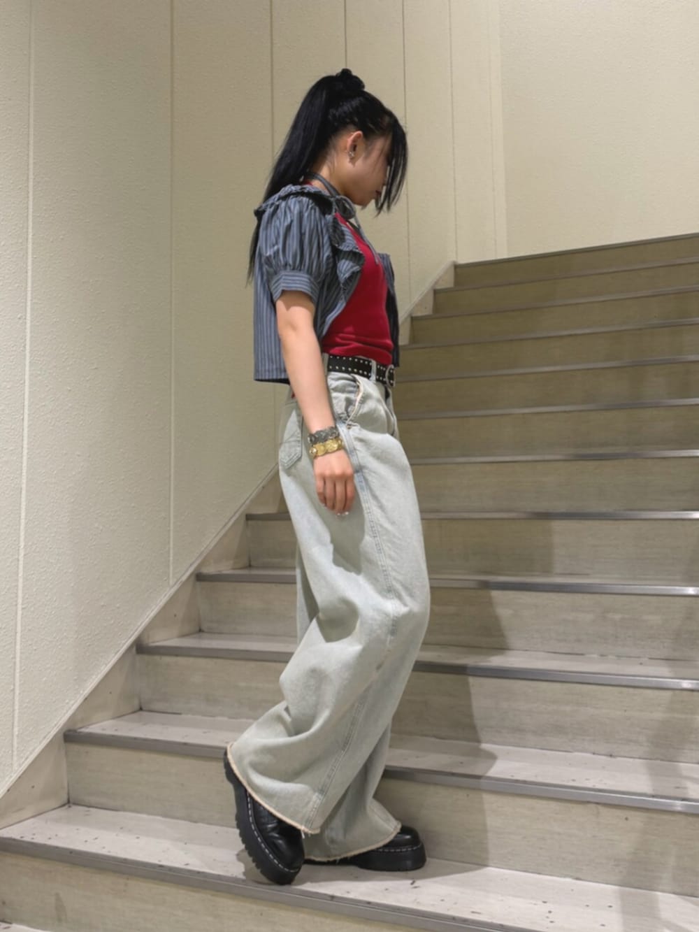 レッド系のキャミソール、ブルー系のデニムパンツ、ブラック系のシャツ/ブラウスを着用したレディースの夏コーディネートの2枚目の写真