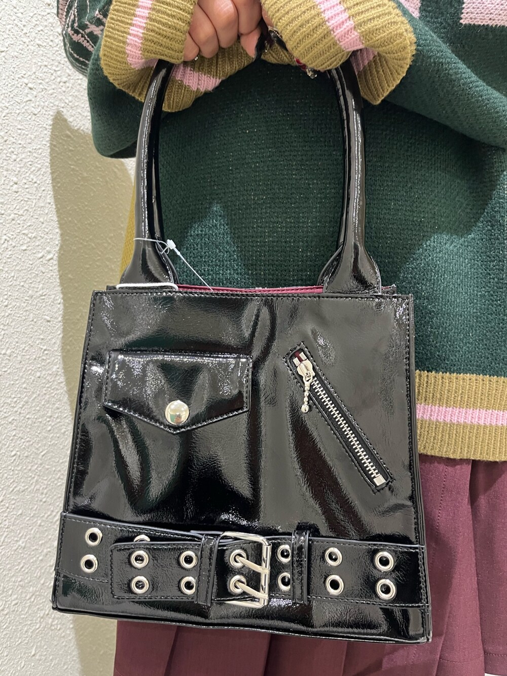 ブラック系のニット/セーター、レッド系のスカート、ブラック系のハンドバッグを着用したレディースの秋コーディネートの6枚目の写真