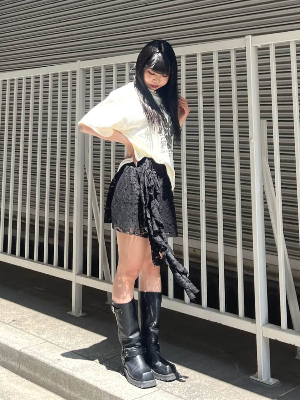 ブラック系のスカート、ホワイト系のTシャツ/カットソー、シルバー系のチョーカーを着用したレディースの夏コーディネートの2枚目の写真