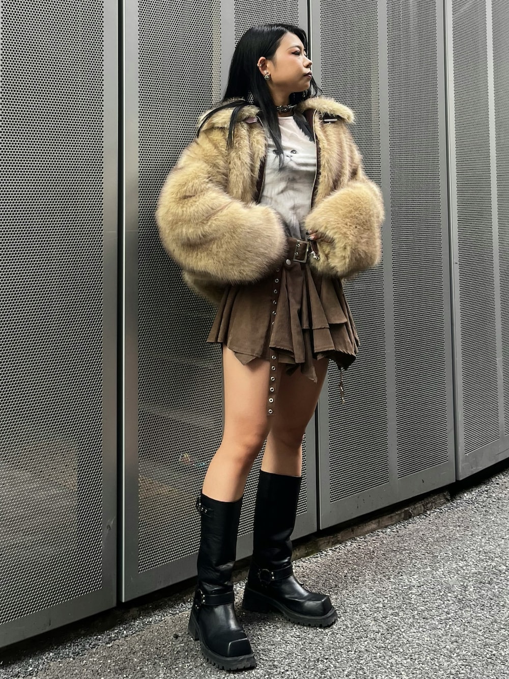 ブラウン系のスカート、ブラック系のブーツ、ベージュ系のその他アウターを着用したレディースの冬コーディネートの2枚目の写真