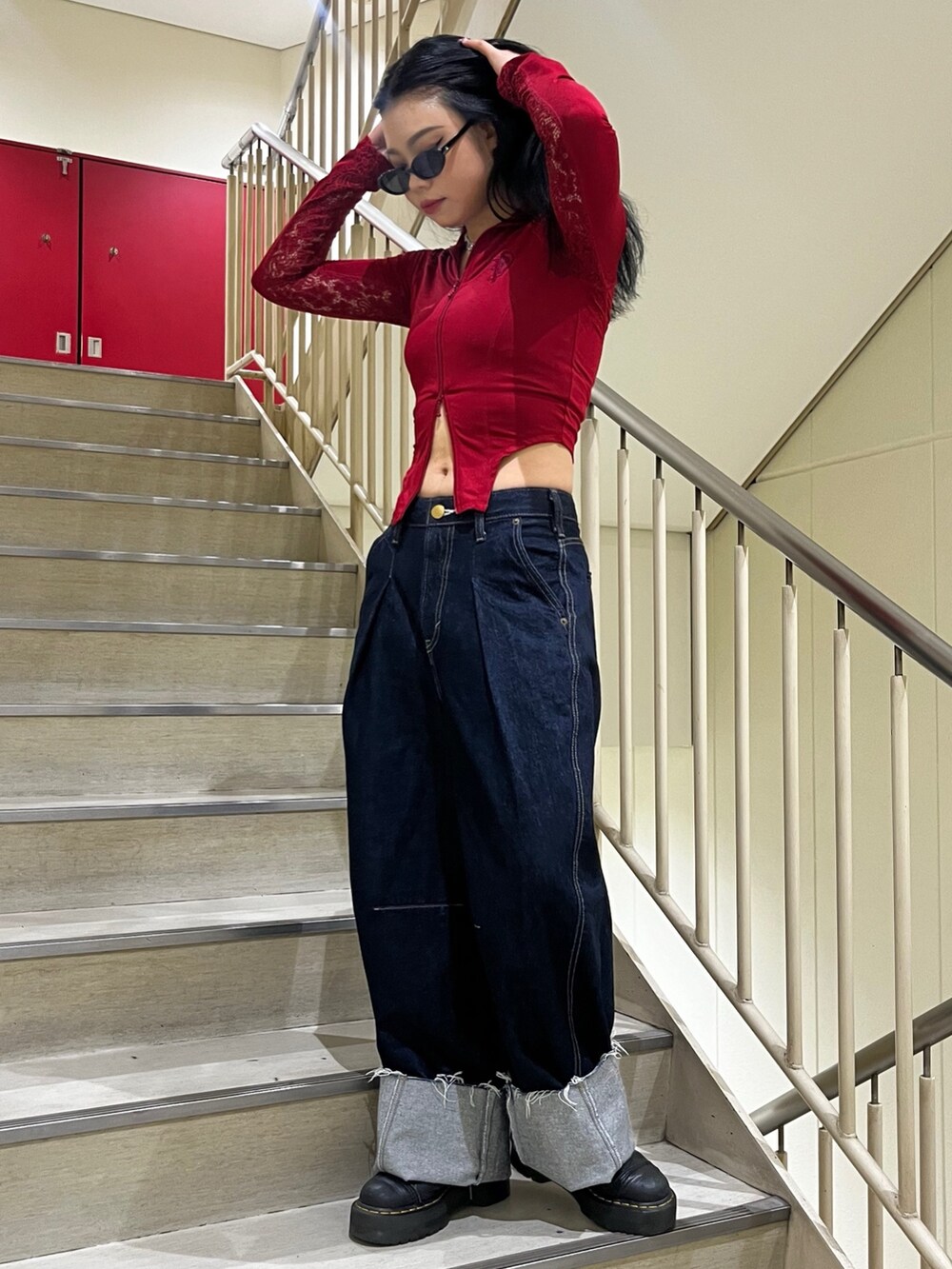 ブルー系のデニムパンツ、レッド系のTシャツ/カットソー、ブラック系のサングラスを着用したレディースの夏コーディネートの6枚目の写真