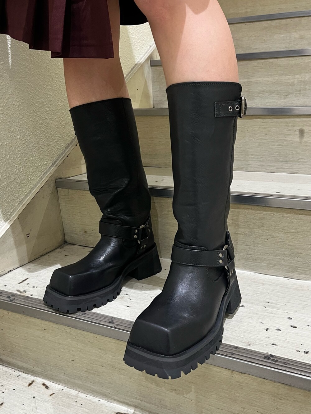 ブラック系のニット/セーター、レッド系のスカート、ブラック系のハンドバッグを着用したレディースの秋コーディネートの7枚目の写真