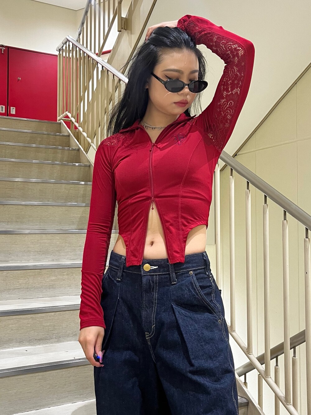 ブルー系のデニムパンツ、レッド系のTシャツ/カットソー、ブラック系のサングラスを着用したレディースの夏コーディネートの4枚目の写真