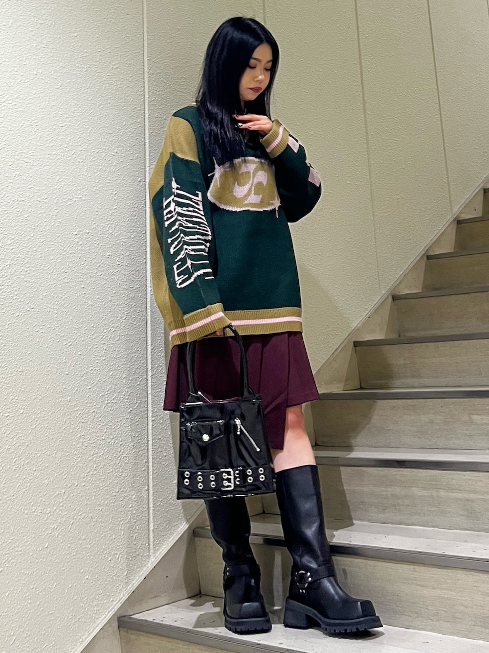 ブラック系のニット/セーター、レッド系のスカート、ブラック系のハンドバッグを着用したレディースの秋コーディネートの3枚目の写真