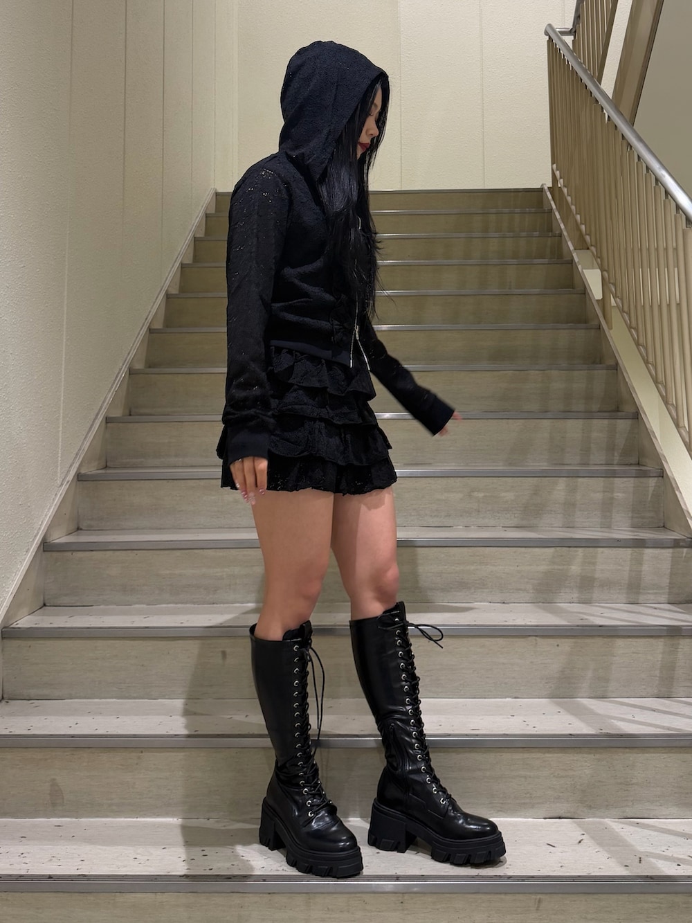 ブラック系のスカート、ブラック系のパーカー、ブラック系のキャミソールを着用したレディースの春コーディネートの2枚目の写真