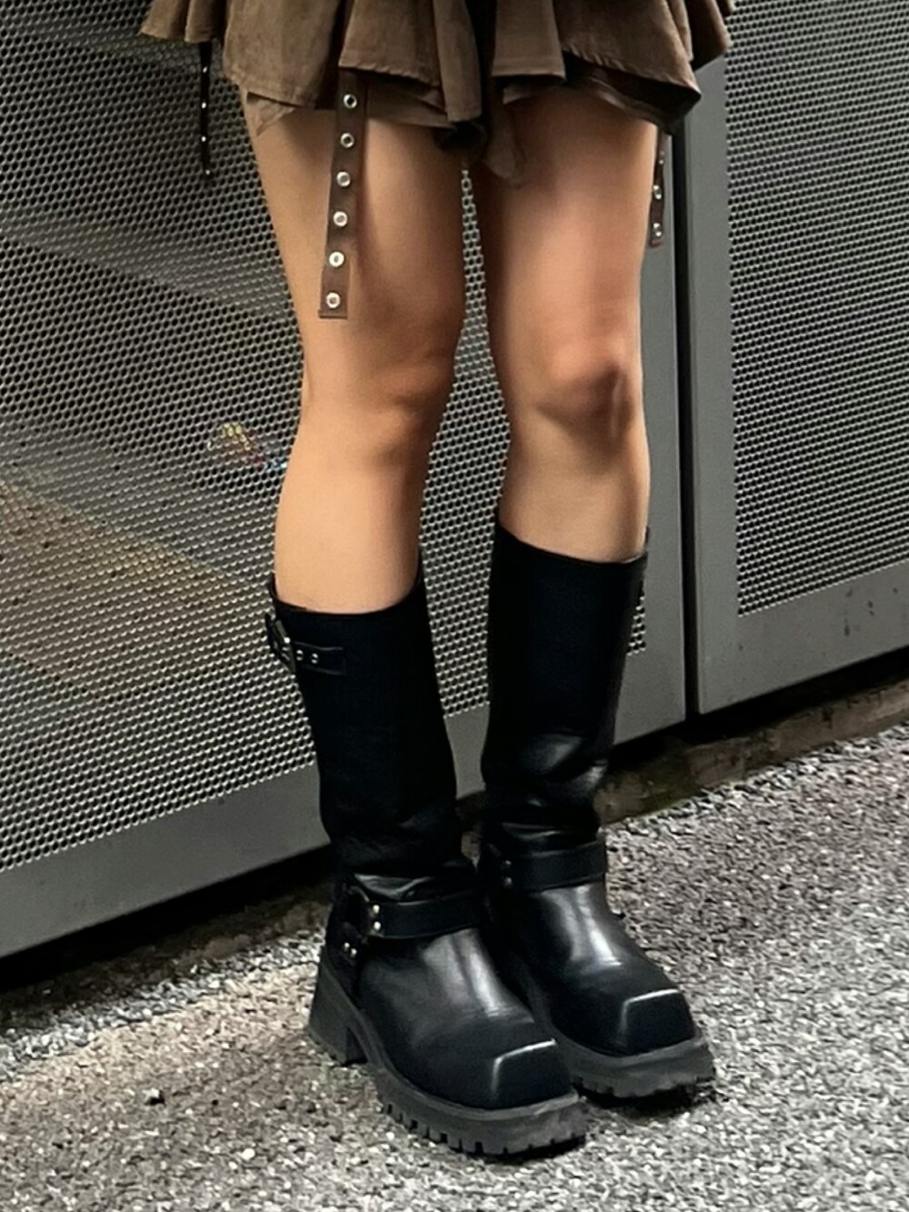 ブラウン系のスカート、ブラック系のブーツ、ベージュ系のその他アウターを着用したレディースの冬コーディネートの7枚目の写真