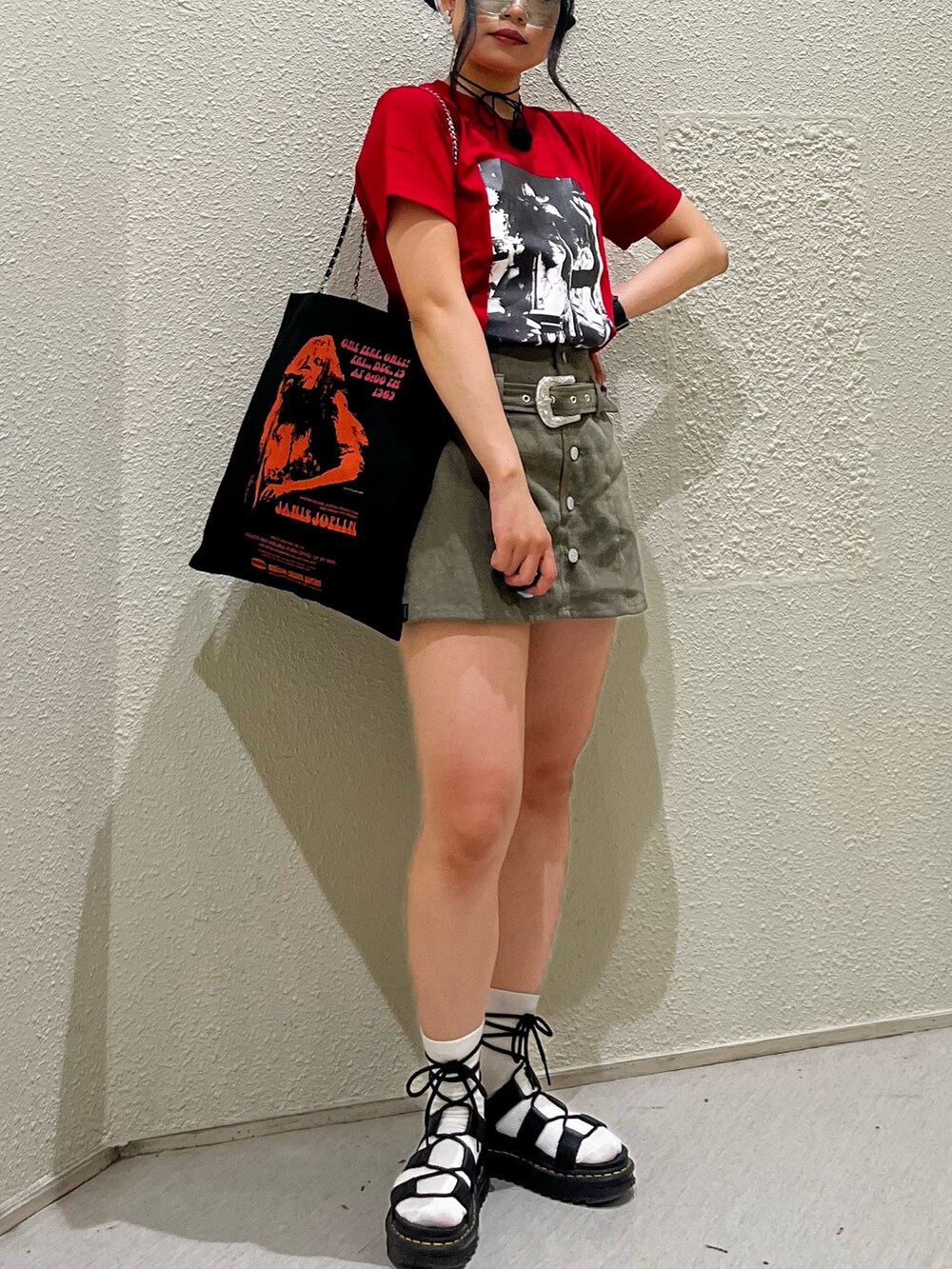 レッド系のTシャツ/カットソー、グリーン系のスカート、ブラック系のトートバッグを着用したレディースの夏コーディネートの8枚目の写真