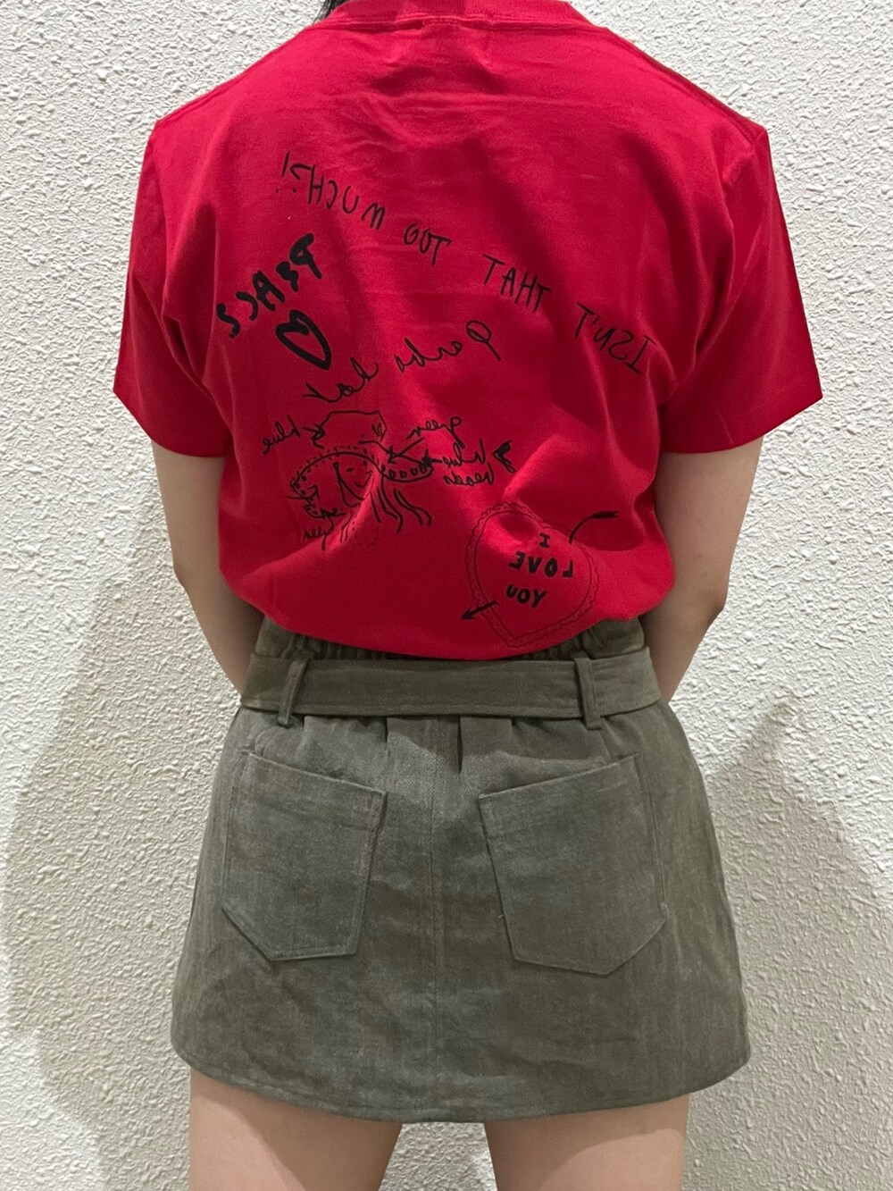 レッド系のTシャツ/カットソー、グリーン系のスカート、ブラック系のトートバッグを着用したレディースの夏コーディネートの6枚目の写真