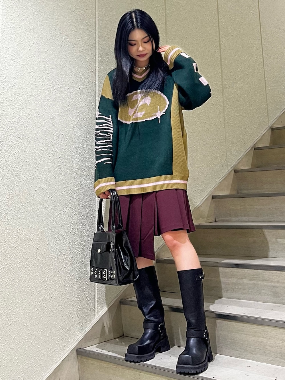 ブラック系のニット/セーター、レッド系のスカート、ブラック系のハンドバッグを着用したレディースの秋コーディネートの2枚目の写真