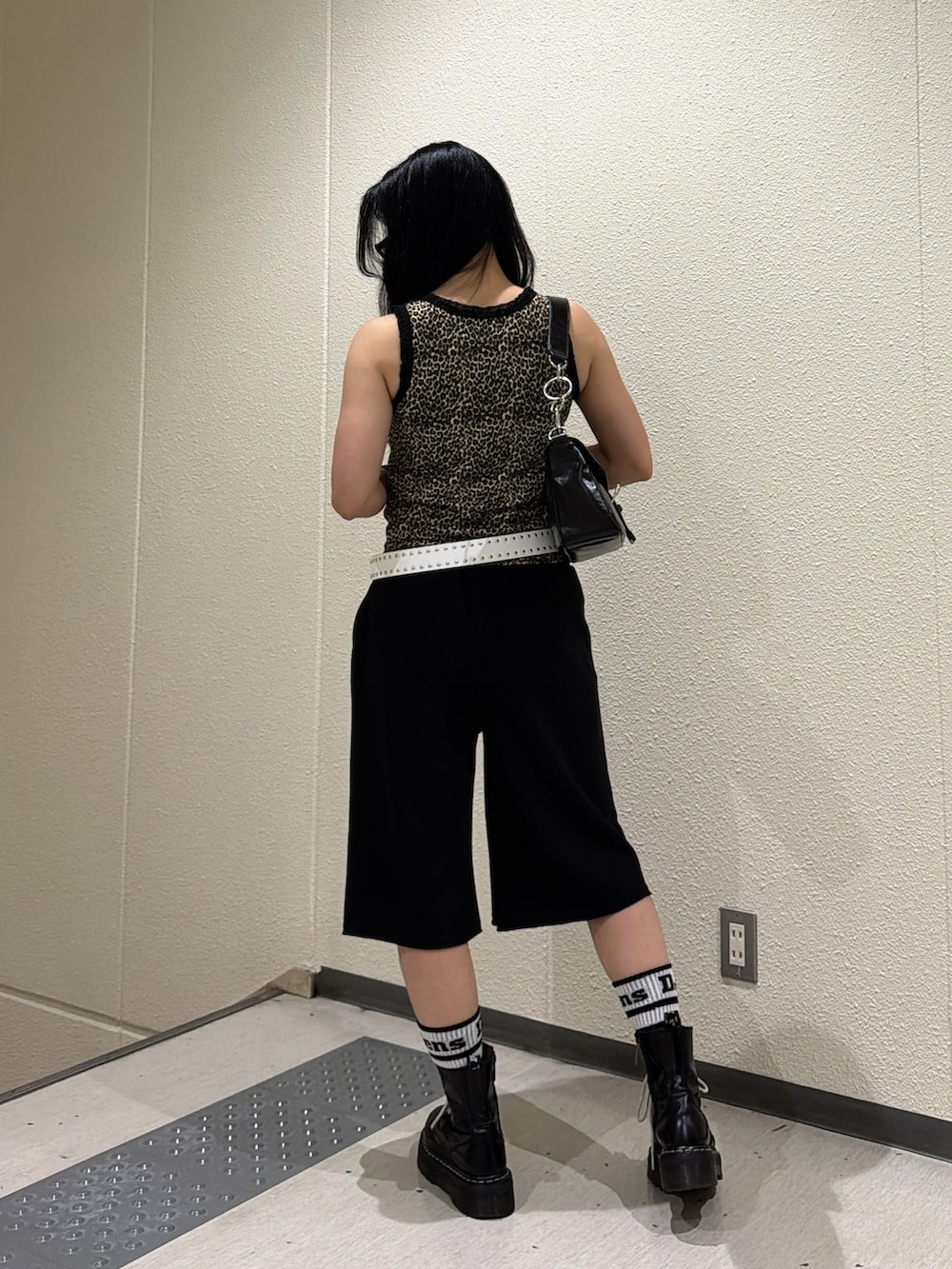 ブラウン系のタンクトップ、ブラック系のその他パンツ、ブラック系のハンドバッグを着用したレディースの夏コーディネートの3枚目の写真