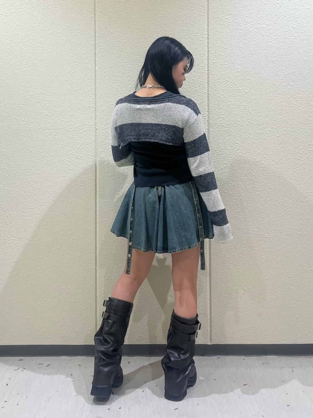 ブラック系のブーツ、ブルー系のデニムスカート、ブラック系のTシャツ/カットソーを着用したレディースの秋コーディネートの3枚目の写真