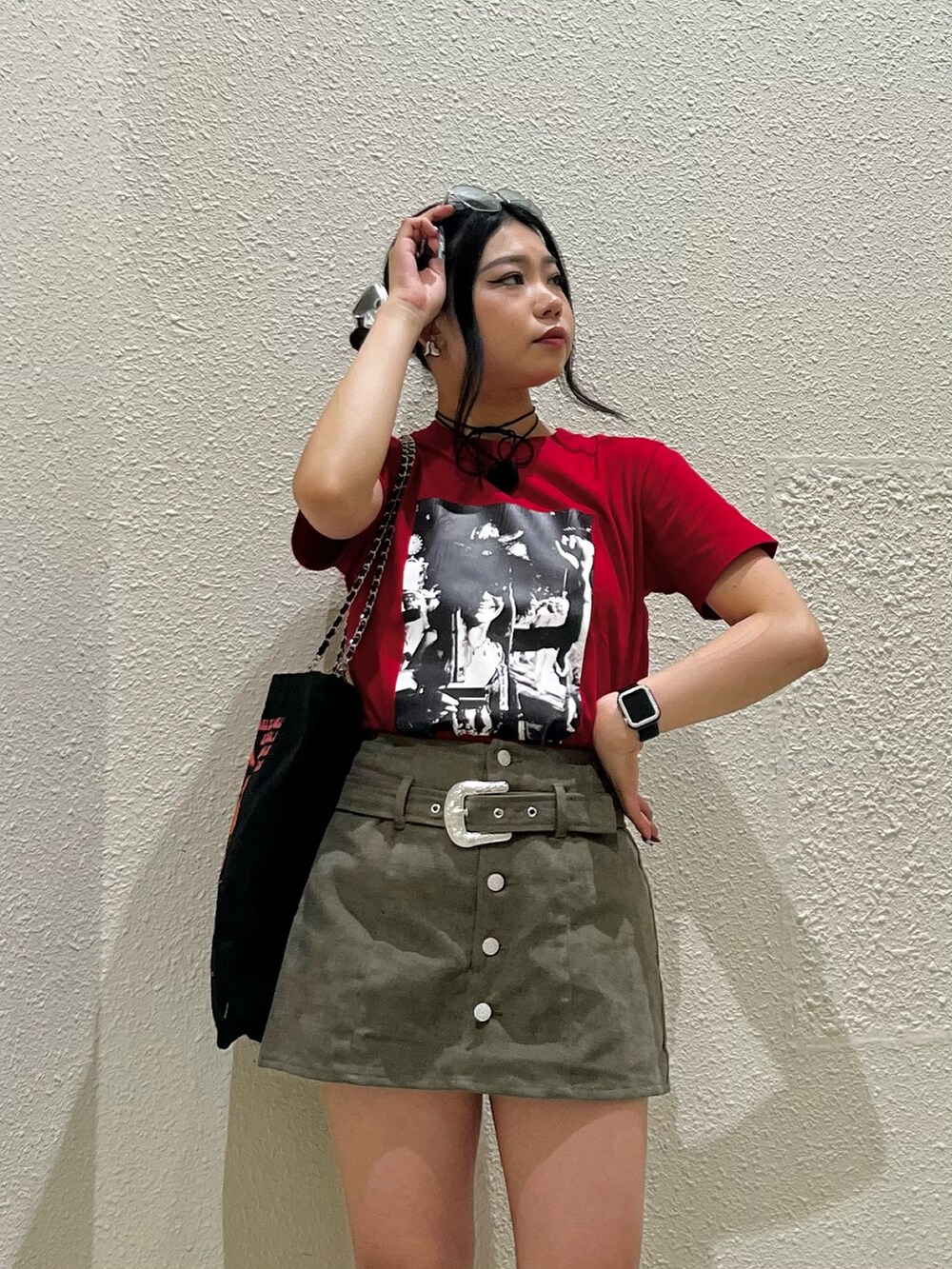 レッド系のTシャツ/カットソー、グリーン系のスカート、ブラック系のトートバッグを着用したレディースの夏コーディネートの4枚目の写真