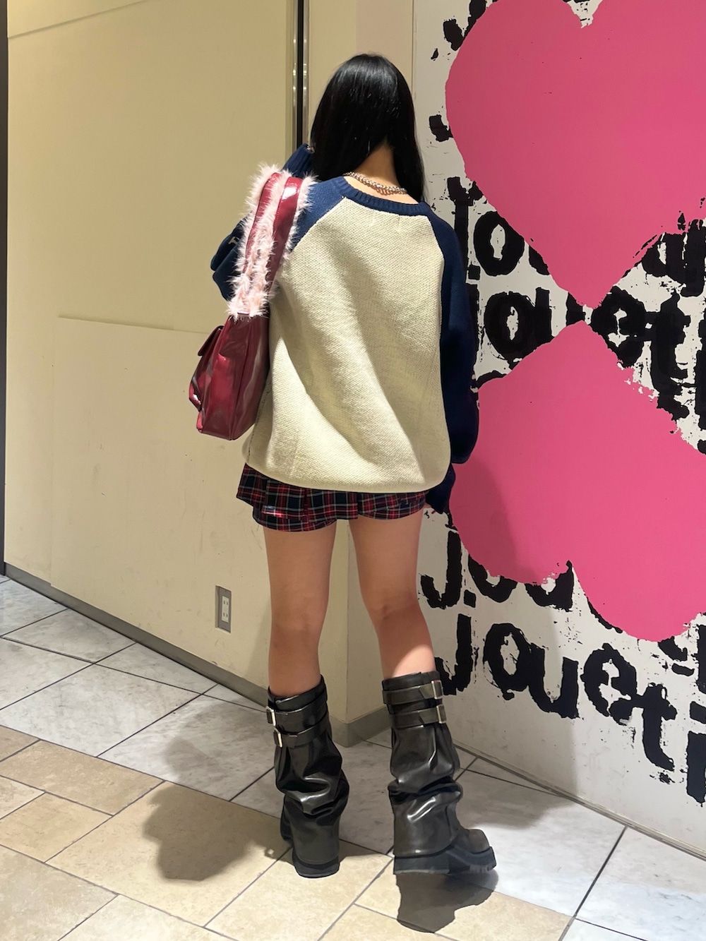 ホワイト系のニット/セーター、ブルー系のスカート、レッド系のハンドバッグを着用したレディースの冬コーディネートの3枚目の写真