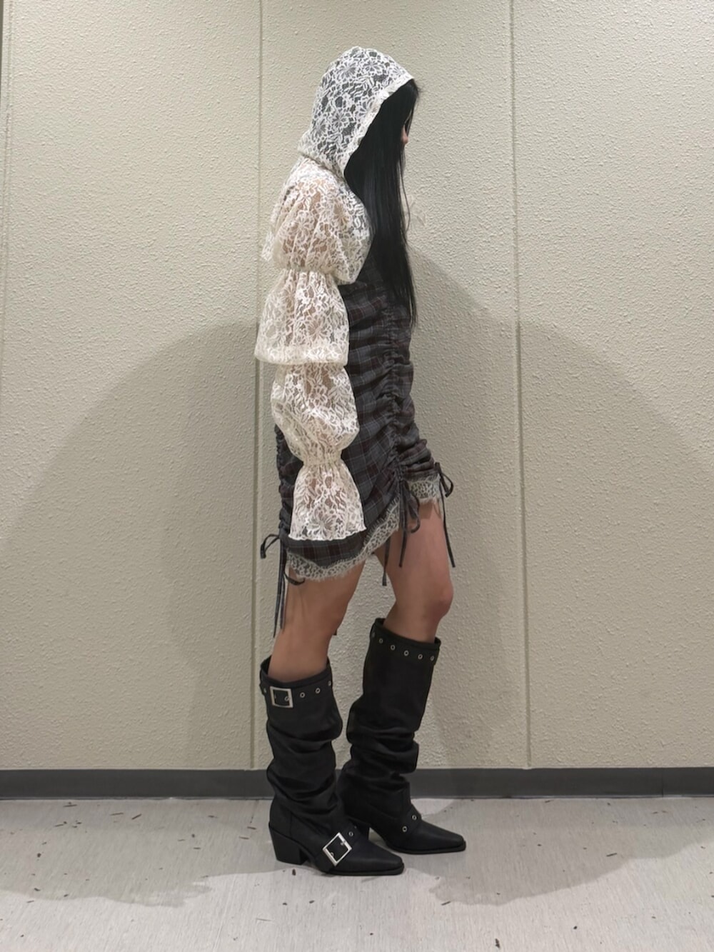 ブラック系のブーツ、ホワイト系のカーディガン/ボレロ、ブラウン系のワンピースを着用したレディースの春コーディネートの2枚目の写真