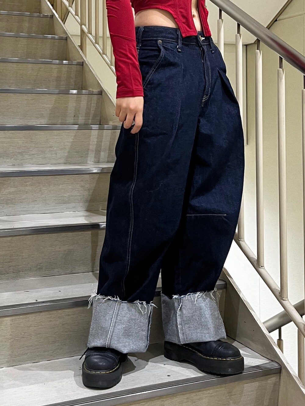 ブルー系のデニムパンツ、レッド系のTシャツ/カットソー、ブラック系のサングラスを着用したレディースの夏コーディネートの5枚目の写真