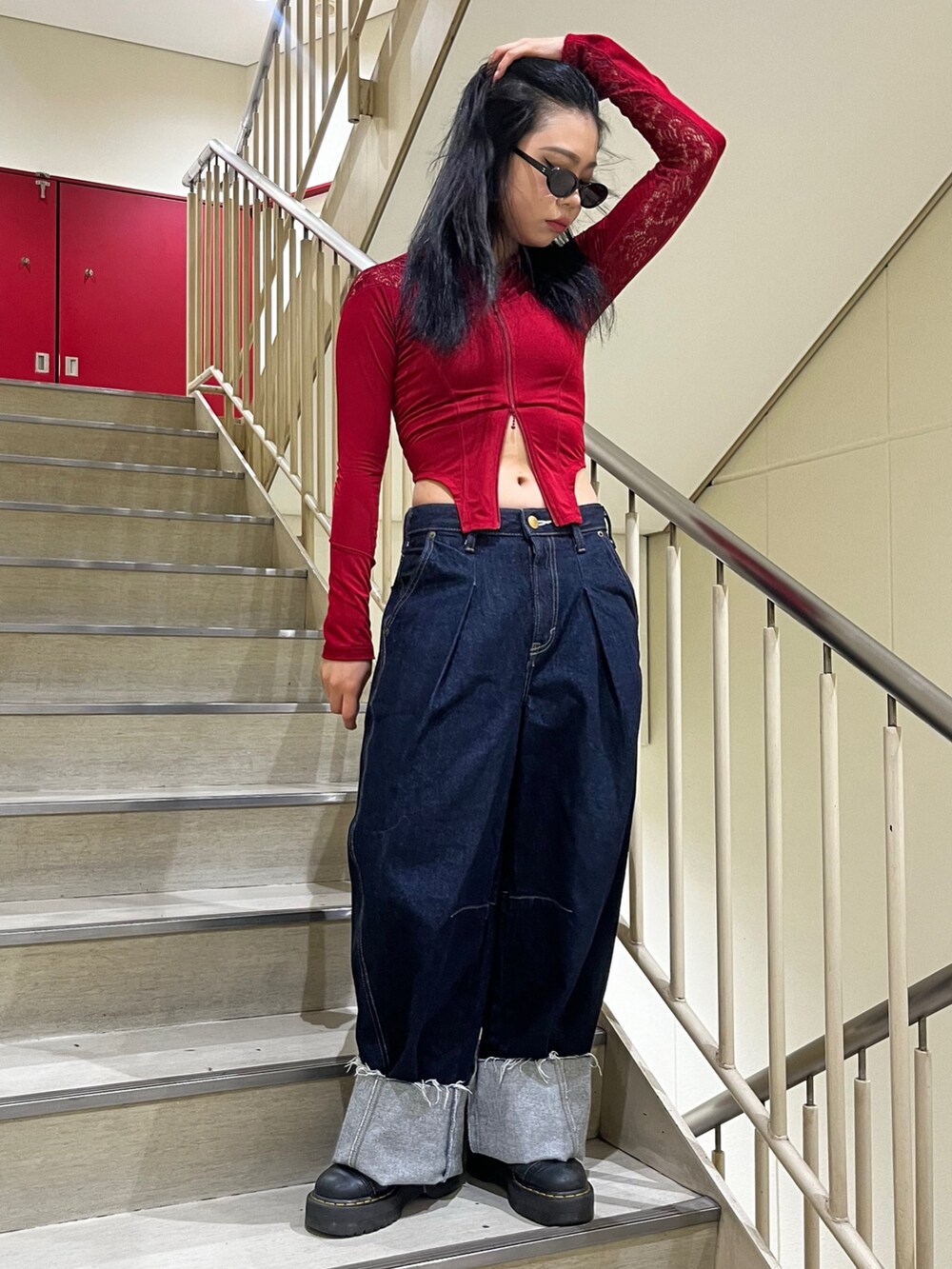 ブルー系のデニムパンツ、レッド系のTシャツ/カットソー、ブラック系のサングラスを着用したレディースの夏コーディネートの2枚目の写真