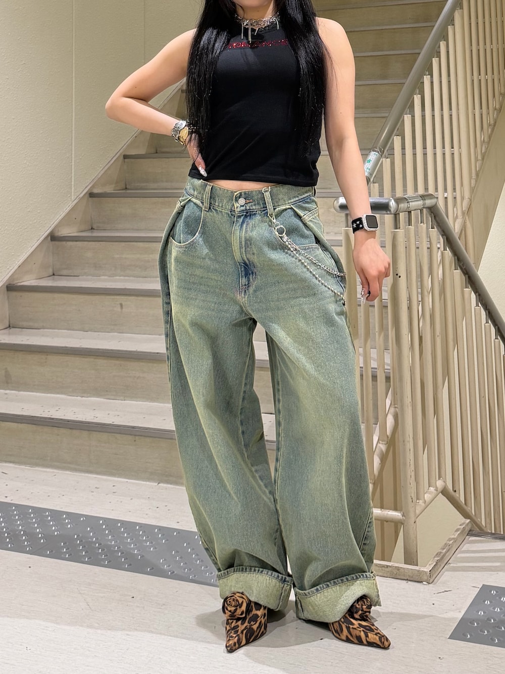 ブルー系のデニムパンツ、ブラック系のタンクトップ、ブラウン系のパンプスを着用したレディースの春コーディネートの5枚目の写真