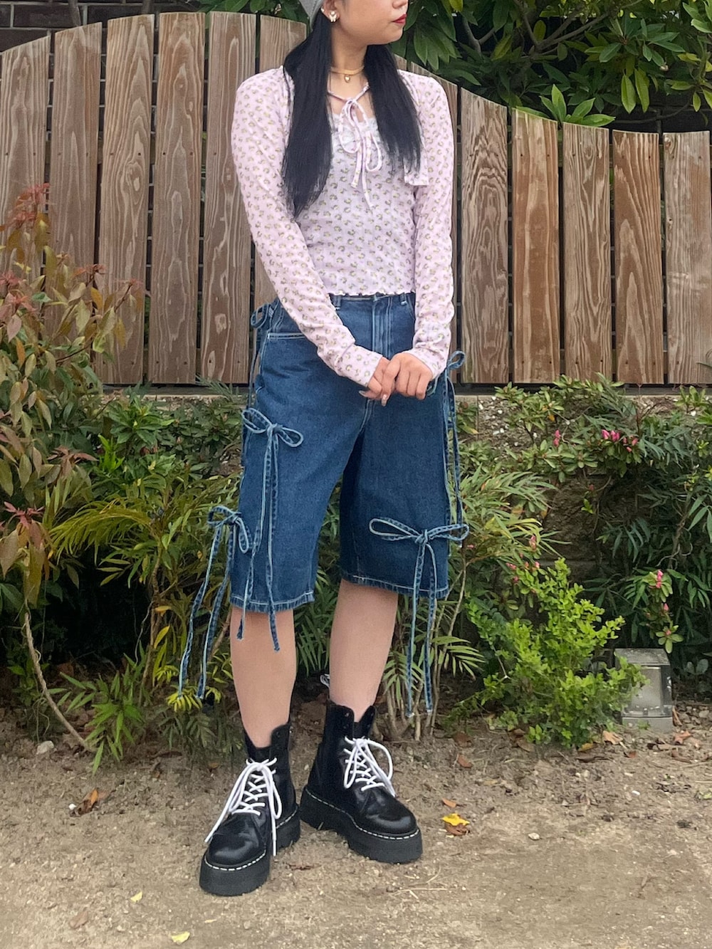 ブルー系のデニムパンツ、ピンク系のアンサンブル、ゴールド系のチョーカーを着用したレディースの春コーディネートの8枚目の写真
