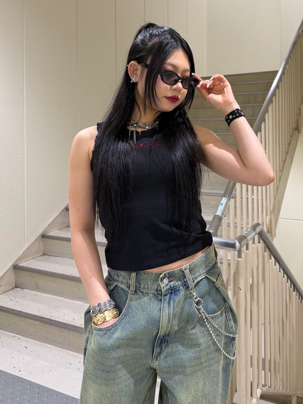 ブルー系のデニムパンツ、ブラック系のタンクトップ、ブラウン系のパンプスを着用したレディースの春コーディネートの4枚目の写真