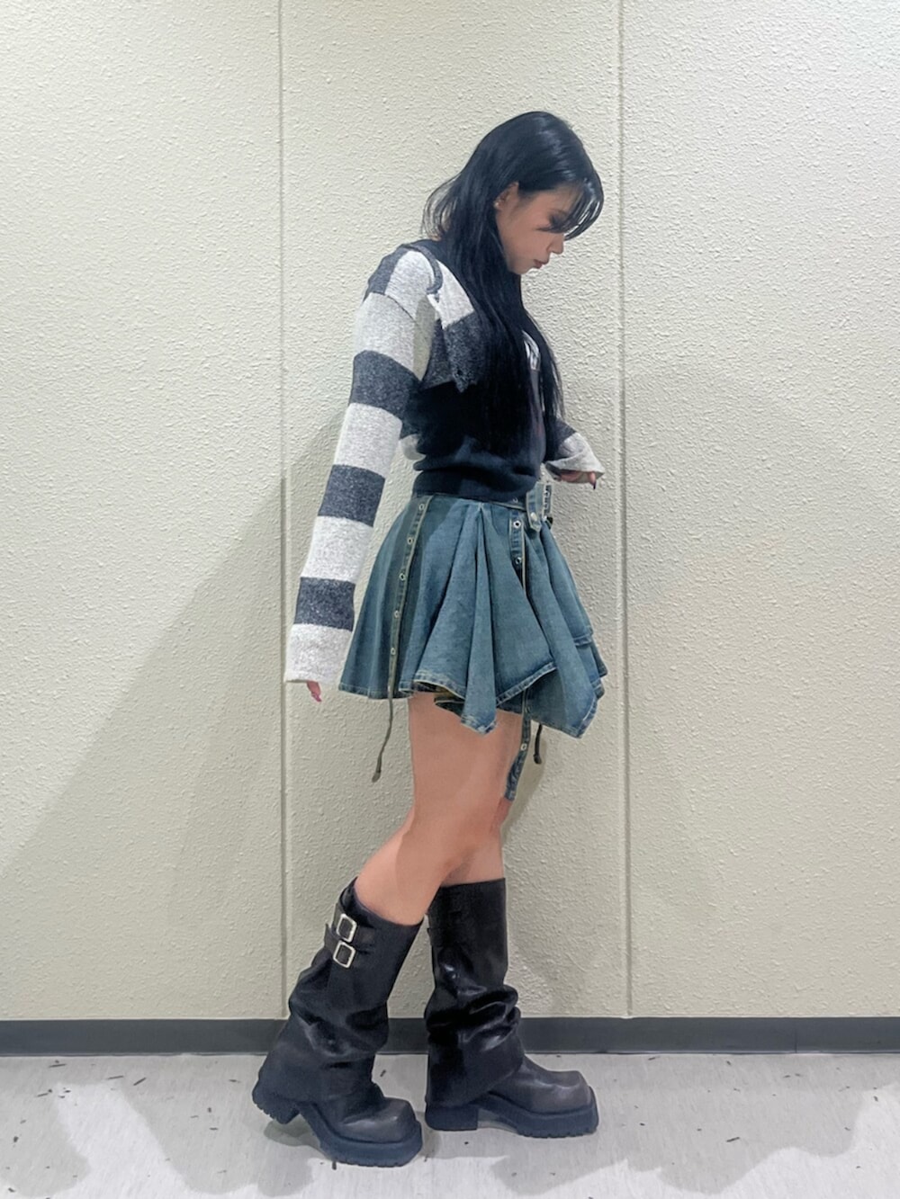 ブラック系のブーツ、ブルー系のデニムスカート、ブラック系のTシャツ/カットソーを着用したレディースの秋コーディネートの2枚目の写真