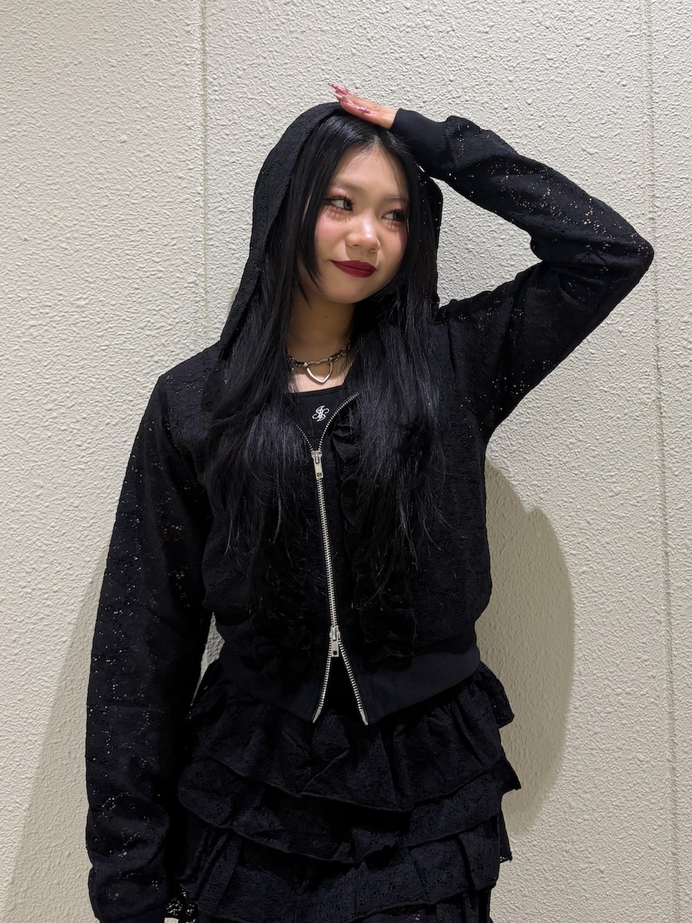 ブラック系のスカート、ブラック系のパーカー、ブラック系のキャミソールを着用したレディースの春コーディネートの4枚目の写真