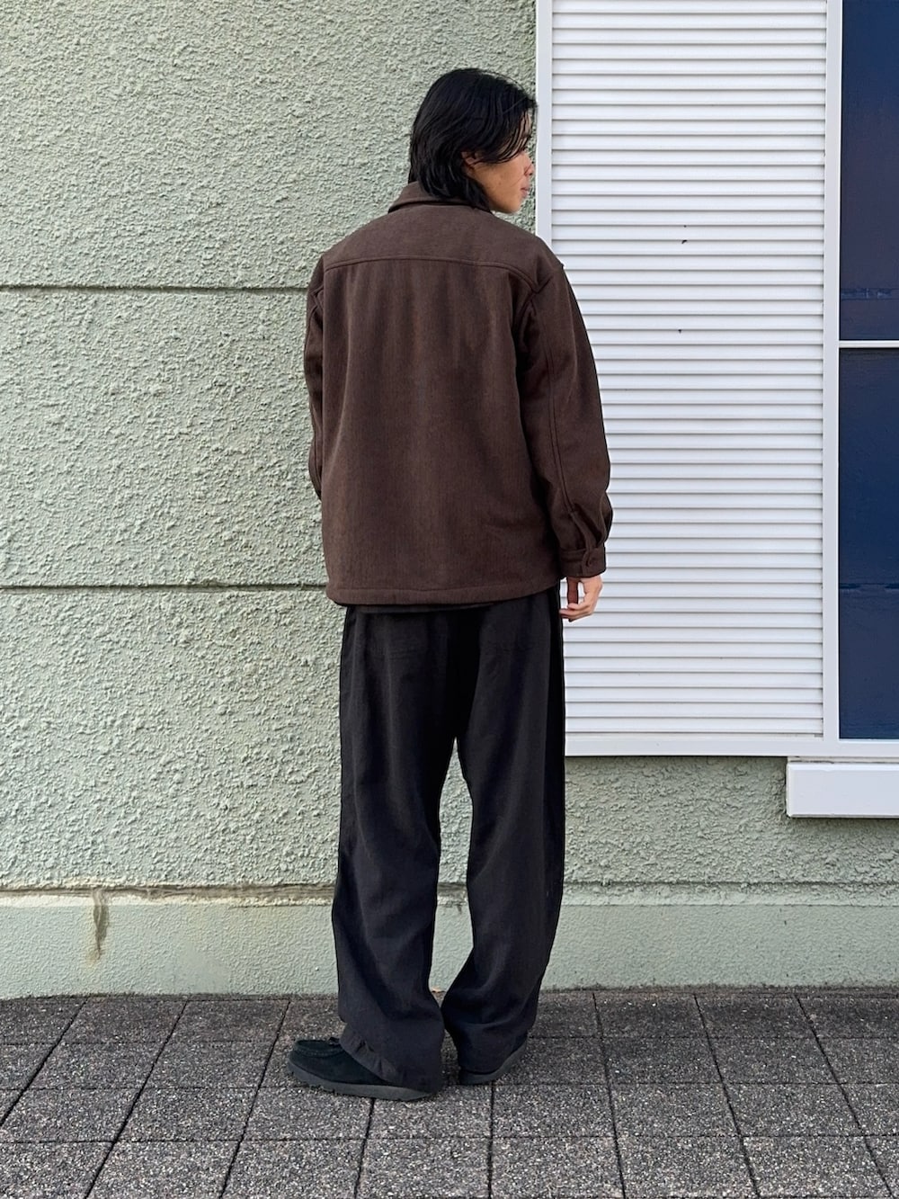 ブラウン系のその他アウター、ブラック系のその他パンツを着用したメンズの冬コーディネートの2枚目の写真