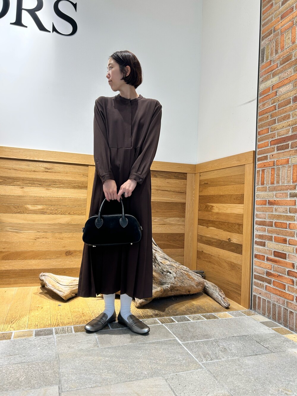 ブラック系のショルダーバッグ、ブラウン系のワンピースを着用したレディースの秋コーディネートの4枚目の写真