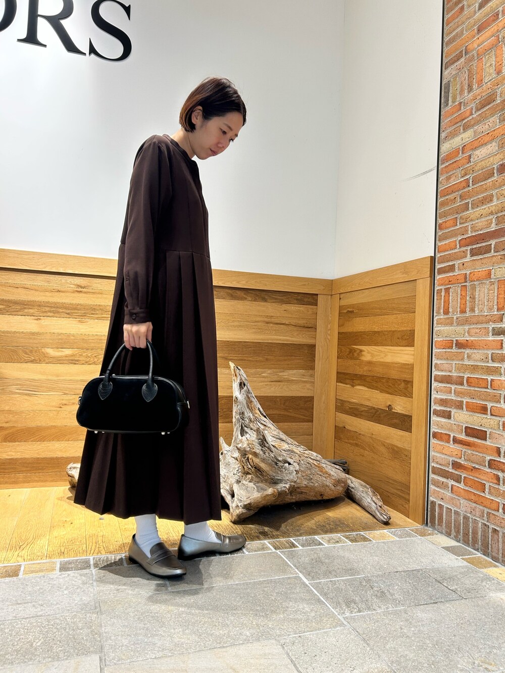 ブラック系のショルダーバッグ、ブラウン系のワンピースを着用したレディースの秋コーディネートの3枚目の写真