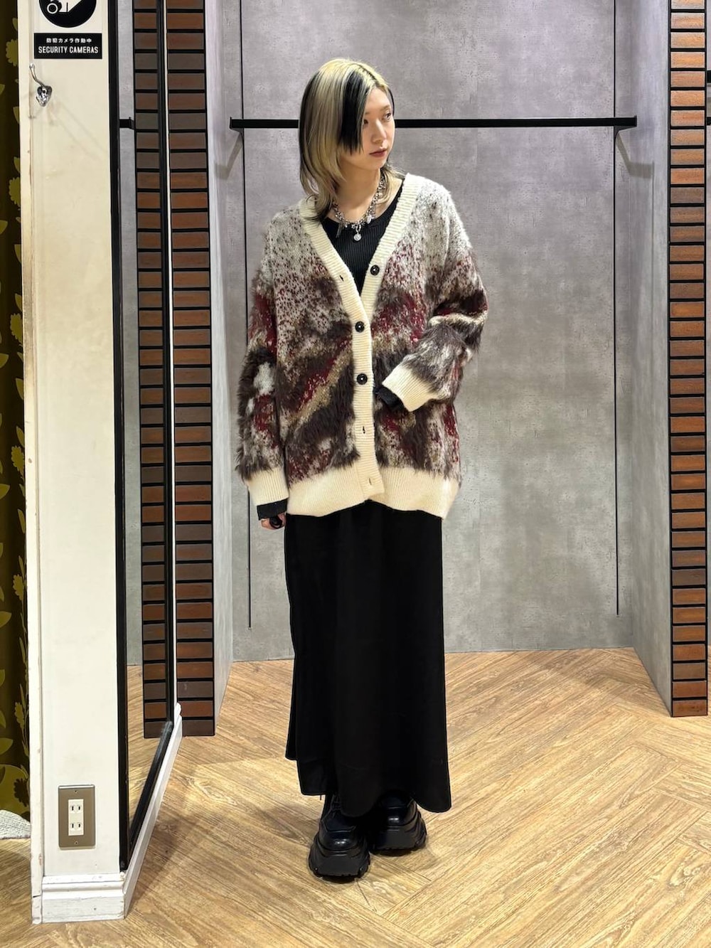 ブラック系のブーツ、ブラック系のニット/セーター、ホワイト系のカーディガン/ボレロを着用したレディースの冬コーディネートの2枚目の写真