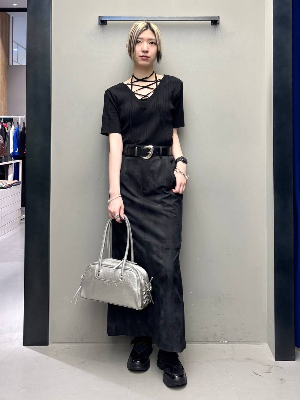 ブラック系のスニーカー、シルバー系のショルダーバッグ、ブラック系のニット/セーターを着用したレディースの春コーディネートの6枚目の写真