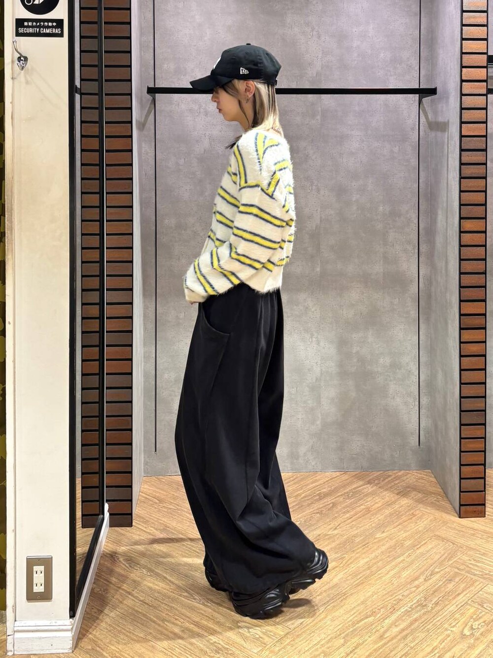 ブラック系のスニーカー、ブラウン系のボストンバッグ、ホワイト系のニット/セーターを着用したレディースの冬コーディネートの4枚目の写真