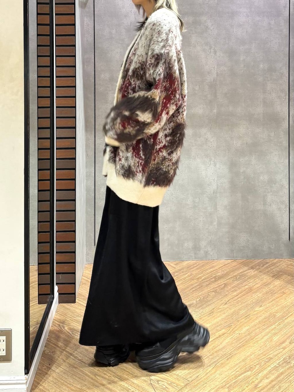 ブラック系のブーツ、ブラック系のニット/セーター、ホワイト系のカーディガン/ボレロを着用したレディースの冬コーディネートの4枚目の写真