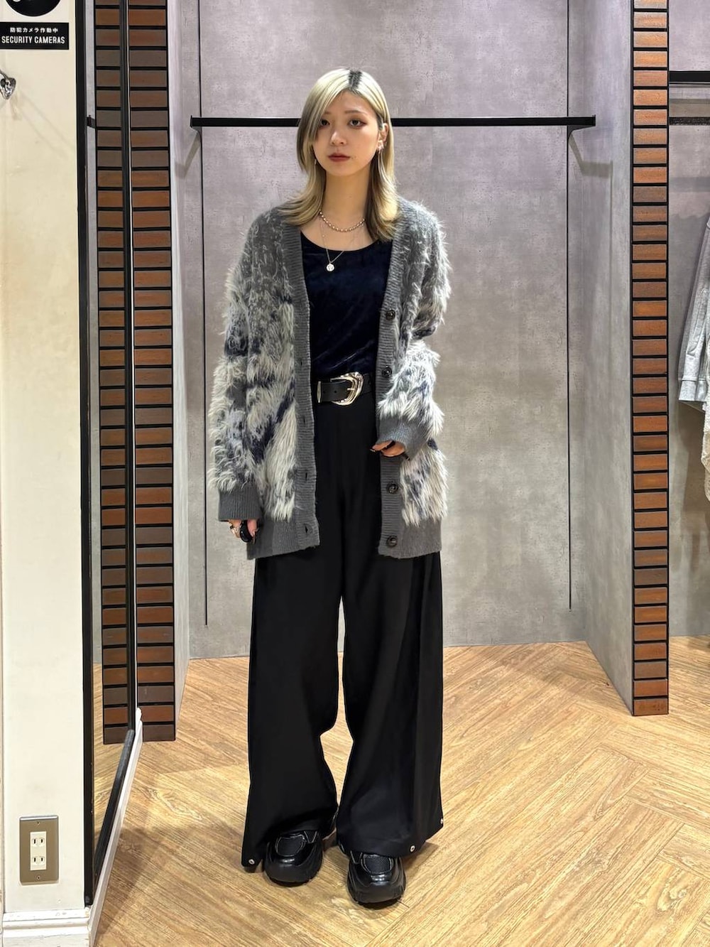 ブラック系のスニーカー、グレー系のカーディガン/ボレロ、ブラック系のスラックスを着用したレディースの秋コーディネートの6枚目の写真