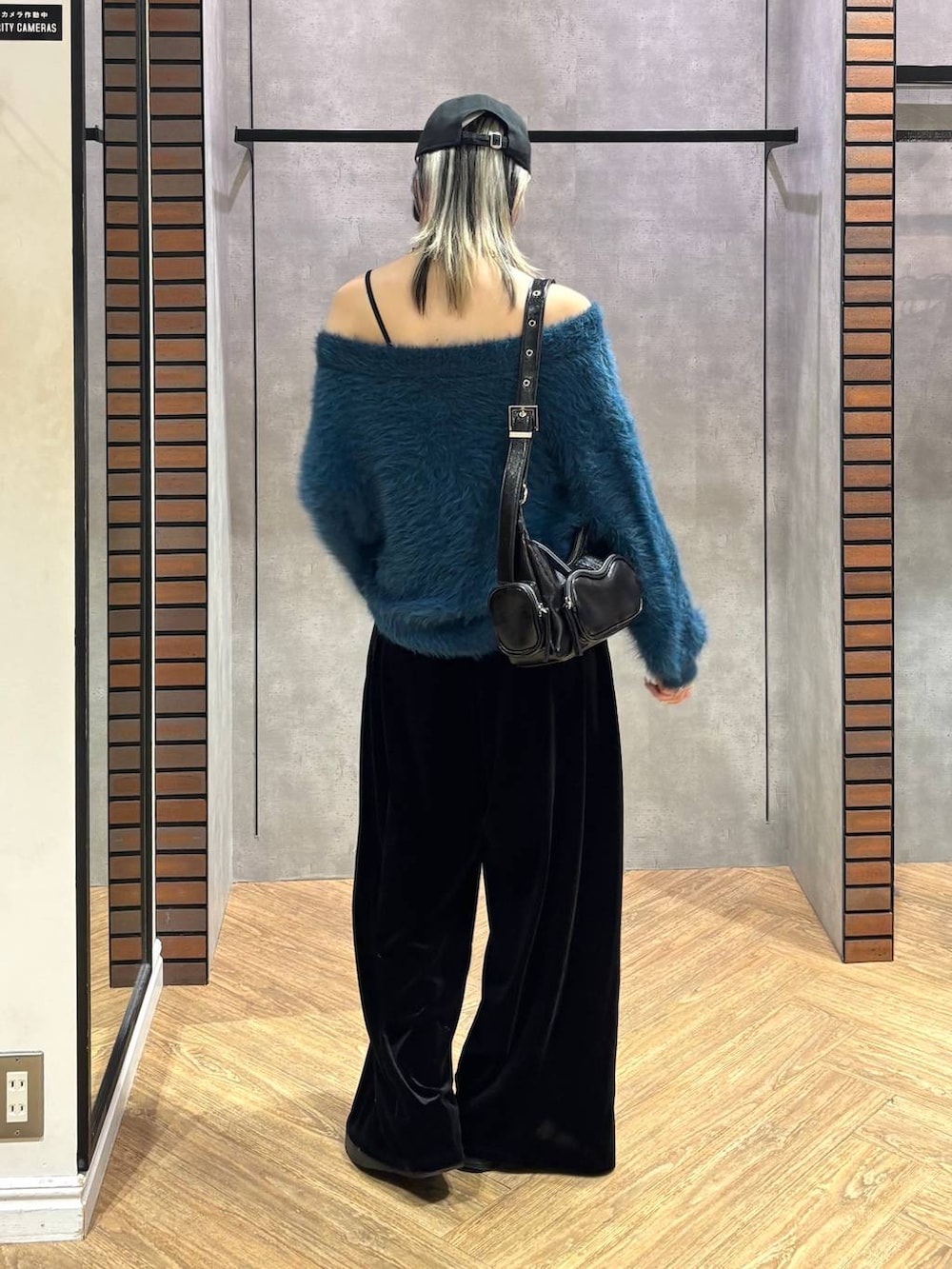 ブラック系のショルダーバッグ、ブルー系のニット/セーター、ブラック系のその他パンツを着用したレディースの冬コーディネートの5枚目の写真