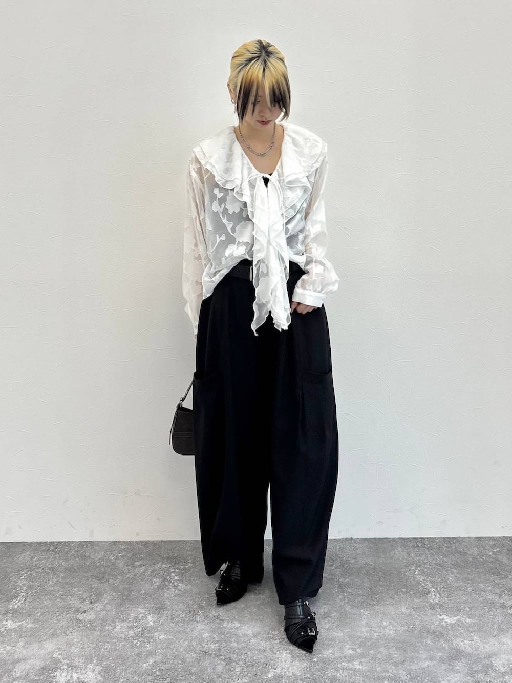 ブラウン系のハンドバッグ、ブラック系のサンダル、ホワイト系のシャツ/ブラウスを着用したレディースの春コーディネートの5枚目の写真