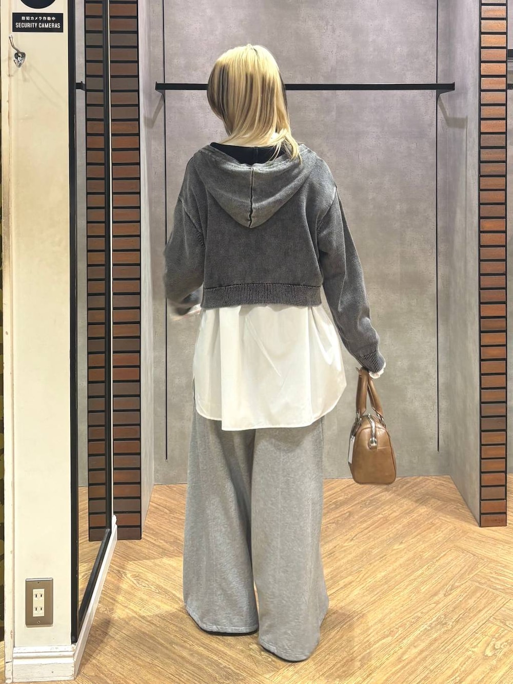 ブラウン系のボストンバッグ、ブラック系のスニーカー、グレー系のスウェットパンツを着用したレディースの冬コーディネートの6枚目の写真