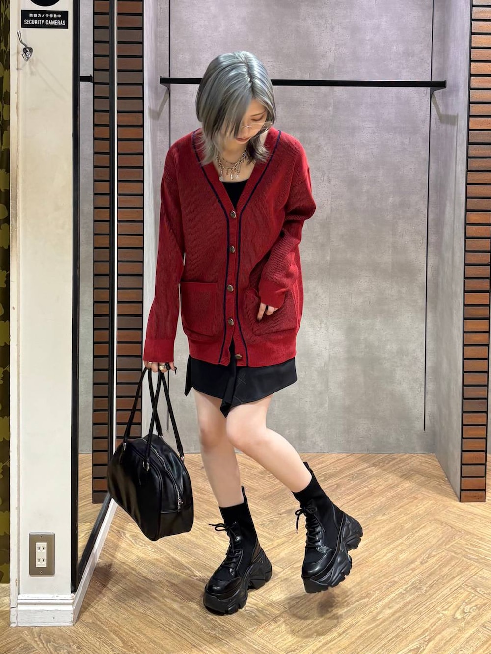 ブラック系のブーツ、ブラック系のキャミソール、ブラック系のスカートを着用したレディースの秋コーディネートの3枚目の写真