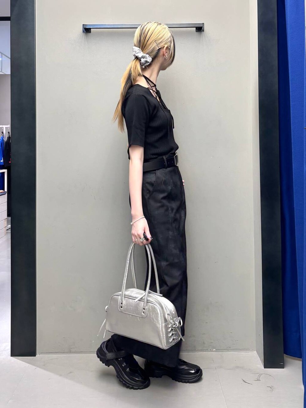 ブラック系のスニーカー、シルバー系のショルダーバッグ、ブラック系のニット/セーターを着用したレディースの春コーディネートの5枚目の写真