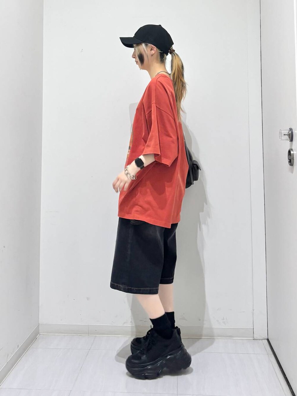 ブラック系のスニーカー、ブラック系のその他パンツ、レッド系のTシャツ/カットソーを着用したレディースの夏コーディネートの4枚目の写真