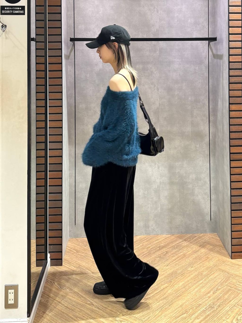 ブラック系のショルダーバッグ、ブルー系のニット/セーター、ブラック系のその他パンツを着用したレディースの冬コーディネートの4枚目の写真