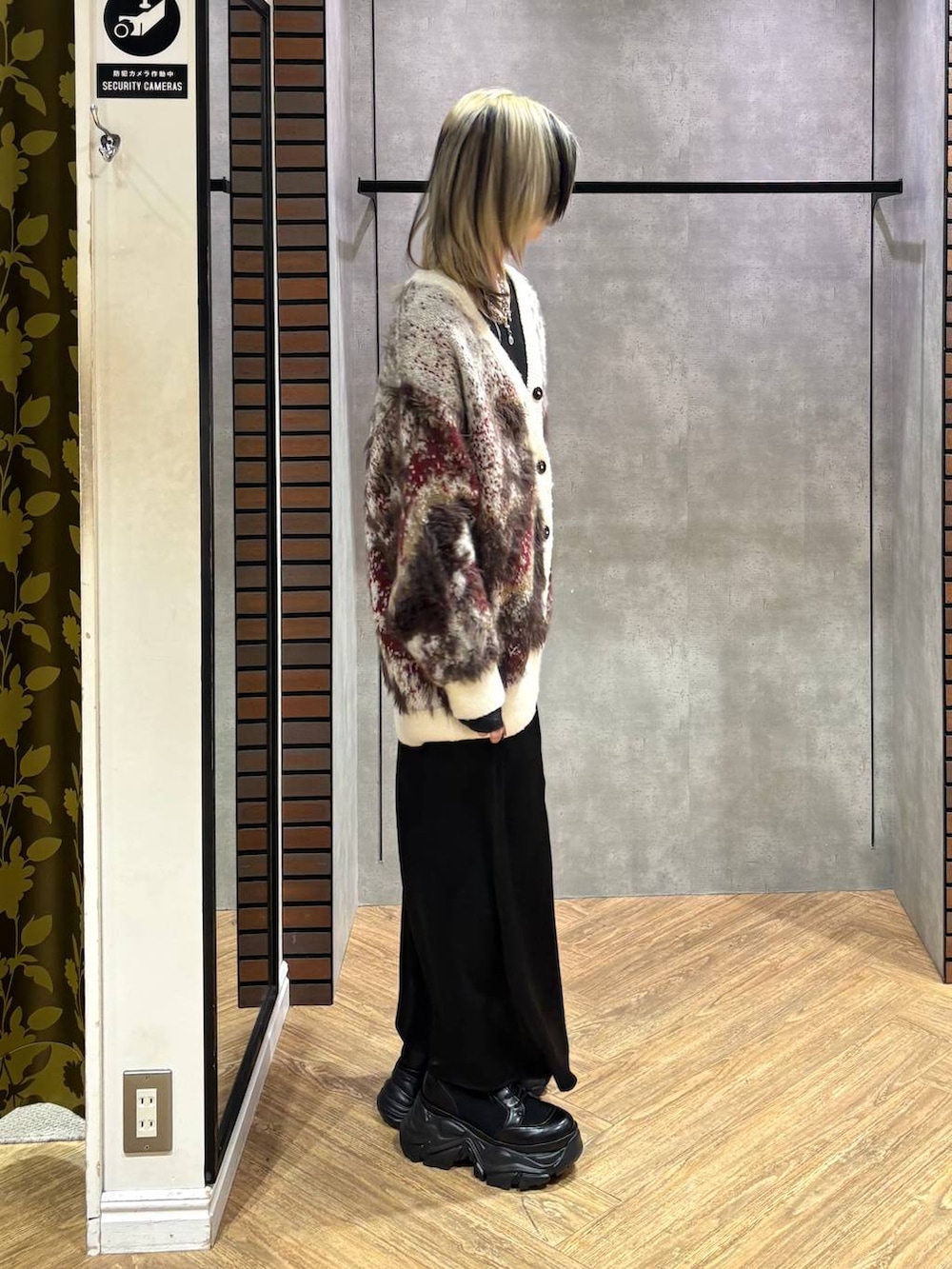 ブラック系のブーツ、ブラック系のニット/セーター、ホワイト系のカーディガン/ボレロを着用したレディースの冬コーディネートの6枚目の写真